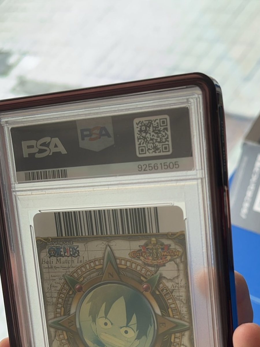一張代送回來的 PSA 鑑定卡背面，殼上有 PSA 全息標、QR 碼與流水號 92561505